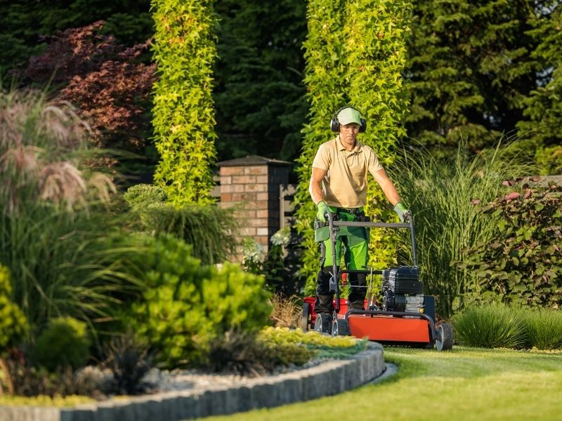 Man mowing lawn with push mower